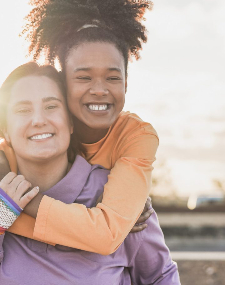 Happy lesbian couple having fun outdoor at sunset